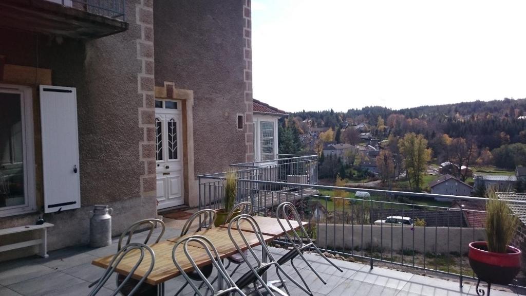 a balcony with tables and chairs on a building at CHEZ TANTE SOLY in Le Chambon-sur-Lignon