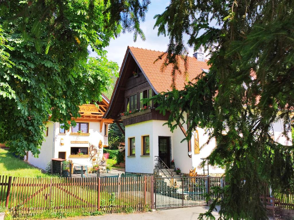ein weißes Haus mit einem Zaun davor in der Unterkunft "Haus Ulla" in Bad Blankenburg