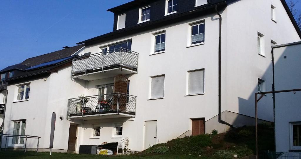 um edifício branco com duas varandas em Ferienwohnung Debray em Winterberg