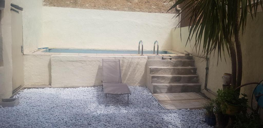 einen Pool mit einem Tisch und einem Stuhl in der Unterkunft La petite maison dans un village bio in Correns