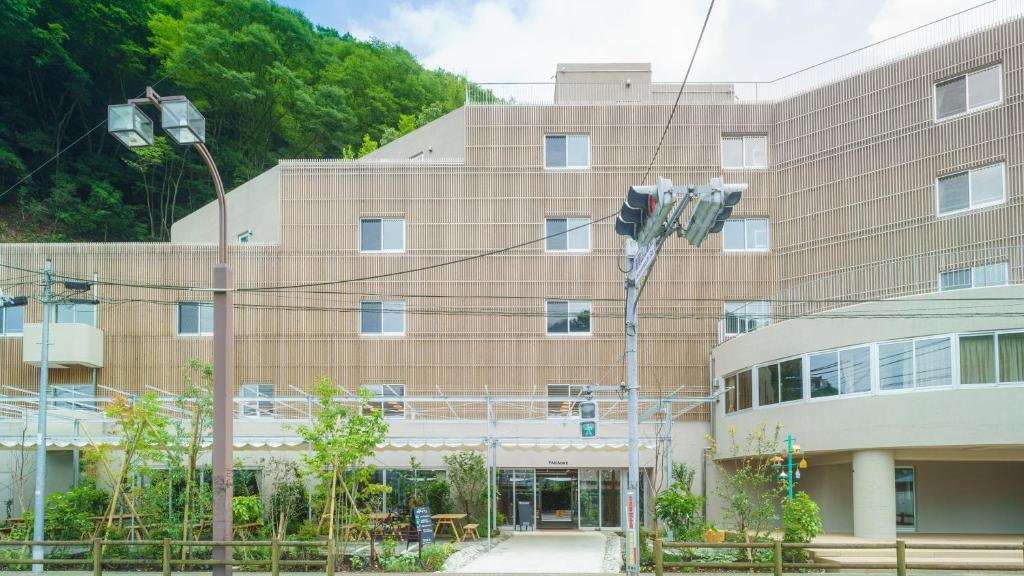 八王子市TAKAONE ACTIVITY＆STAY的前面有路灯的建筑物