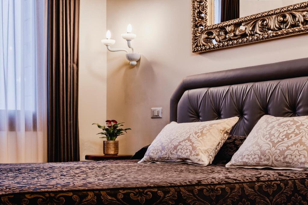 a bedroom with a bed with a leather headboard and two pillows at Porta da mar in Venice