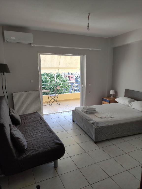 a bedroom with a bed and a couch and a window at Ostria in Preveza