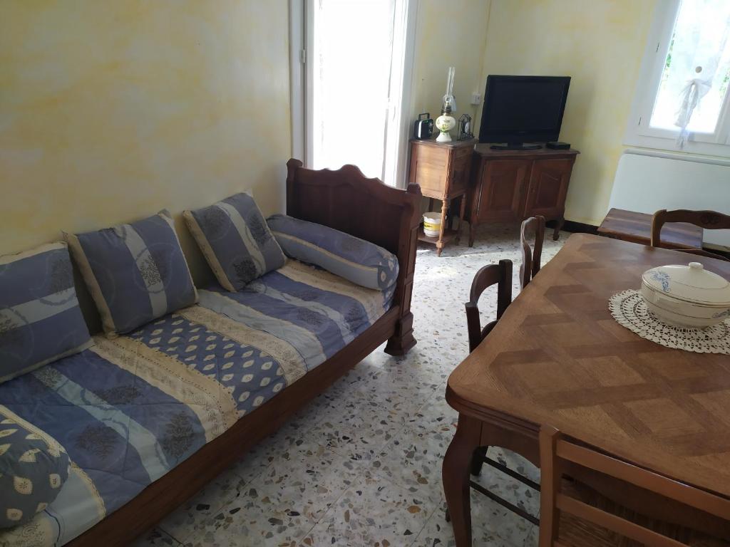 uma sala de estar com um sofá e uma mesa em les mésanges em Chaffaut-Lagremuse