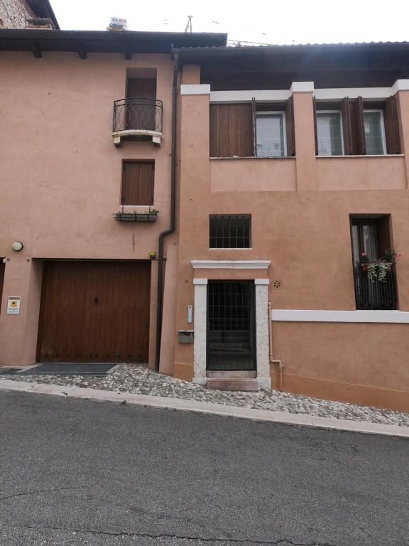un immeuble d'appartements avec un garage et une porte dans l'établissement Al Vecchio Essicatoio, à Bassano del Grappa