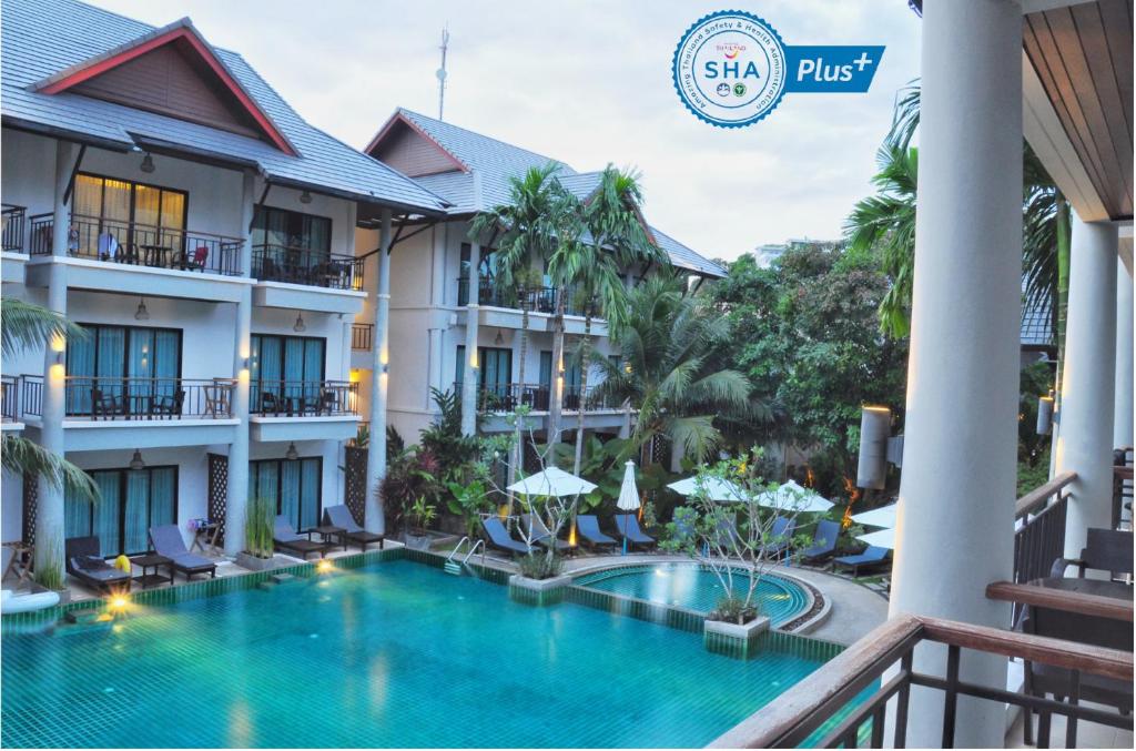a view of the courtyard of a hotel with a swimming pool at Navatara Phuket Resort - SHA Extra Plus in Rawai Beach