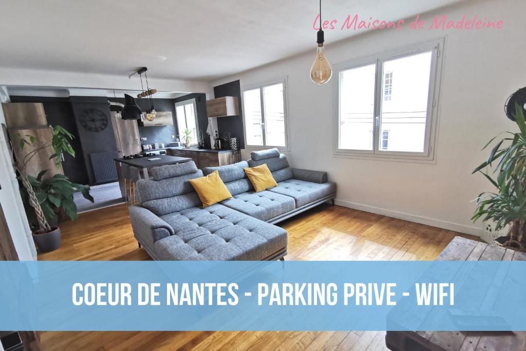 a living room with a gray couch and yellow pillows at Le Globe-trotter - Les Maisons de Madeleine in Nantes