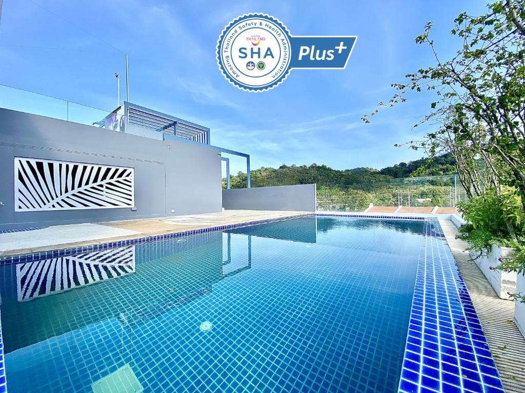 a swimming pool on the side of a house at The Palms Residence - SHA Extra Plus in Phuket Town