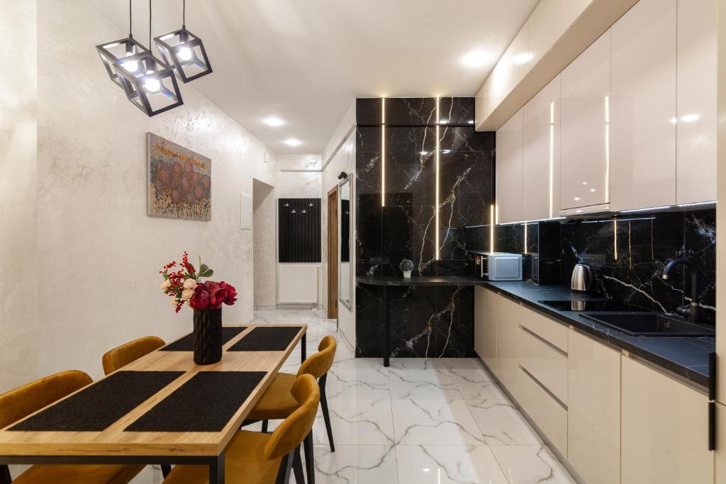 a kitchen with a table and some chairs and a counter at Alfa Apartments Svobody 39 in Lviv