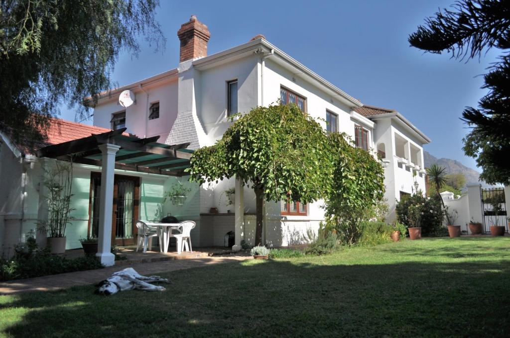 a white house with a table in the yard at Applegarth B&B and Self-Catering Studios in Cape Town