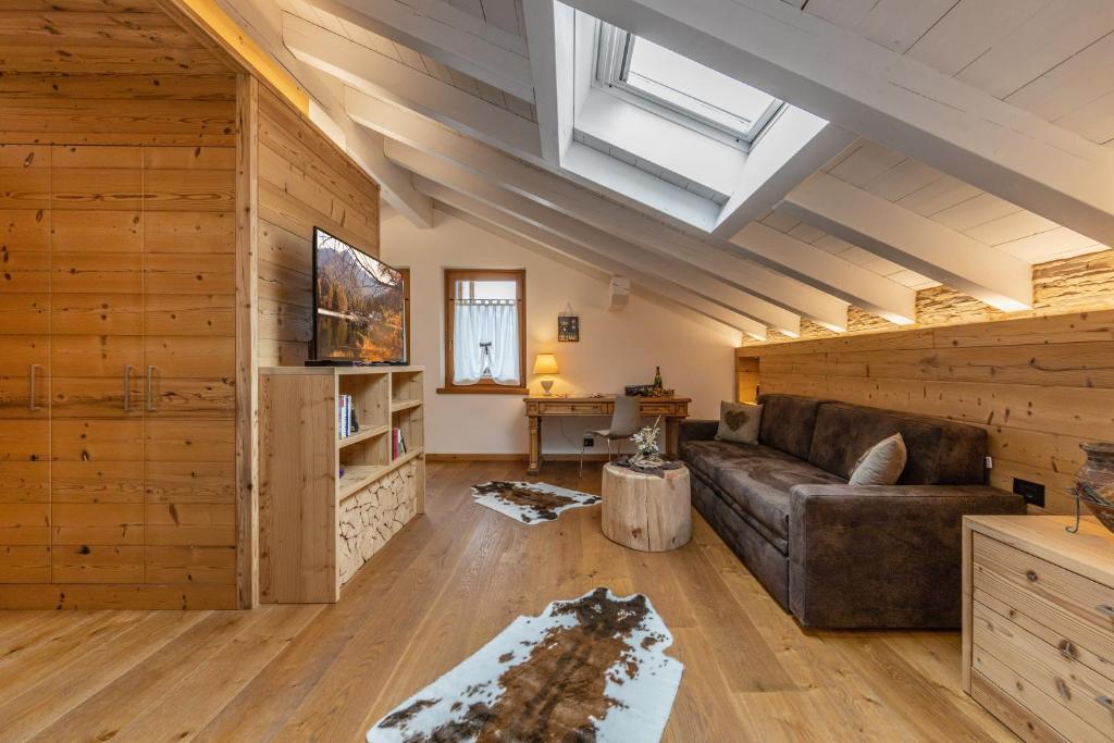 a living room with a couch and a skylight at Chalet Mountain Plaza - Apt Greenvalley in Pinzolo