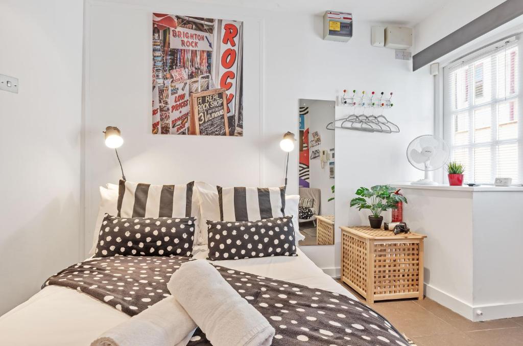 1 dormitorio con 1 cama con almohadas blancas y negras en Artist Studio - By My Getaways, en Brighton & Hove