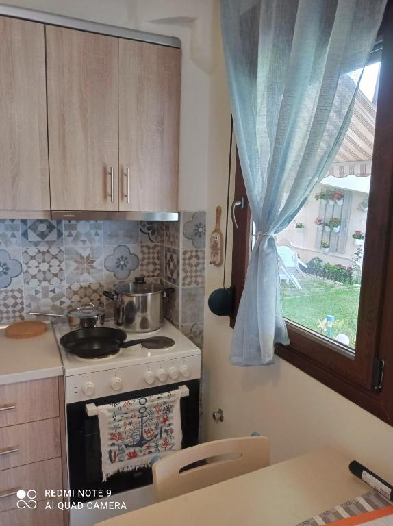 a kitchen with a stove and a window at Sunset Apartment in Epanomi