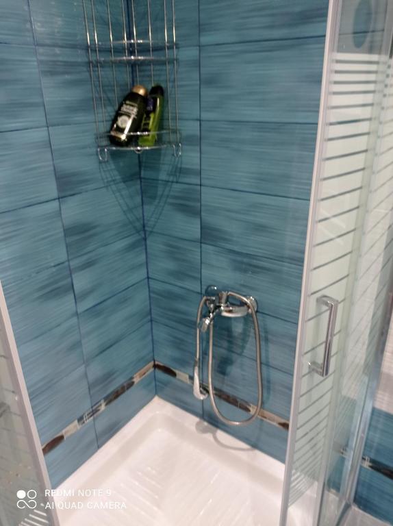 a bath tub with a shower in a bathroom at Sunset Apartment in Epanomi