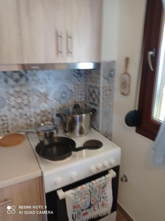 a kitchen with a stove with a pot on it at Sunset Apartment in Epanomi
