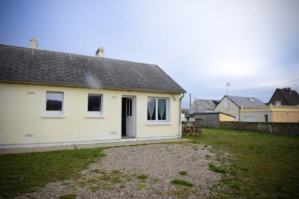 une maison blanche avec une cour devant elle dans l'établissement Maison conviviale à Cayeux-sur-Mer avec jardin, à Cayeux-sur-Mer