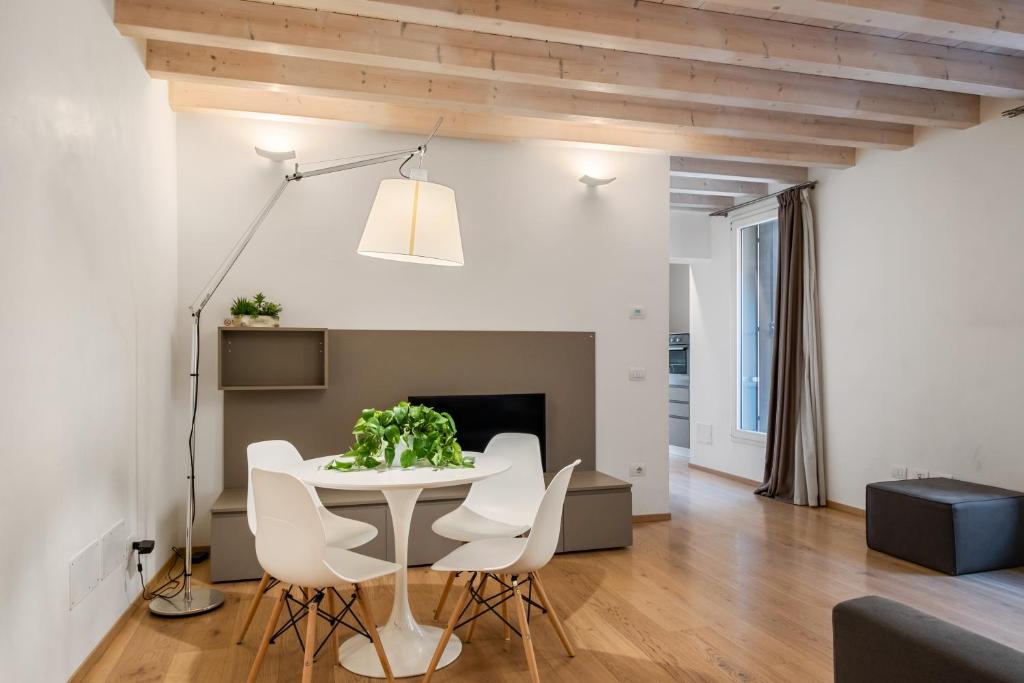 a dining room and living room with a white table and chairs at MyPlace Padova Centro Storico in Padova