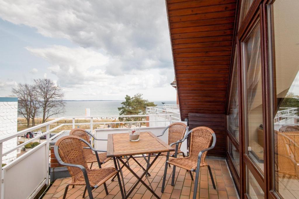 eine Terrasse mit einem Tisch und Stühlen auf dem Balkon in der Unterkunft STR/028 - Strandburg in Scharbeutz