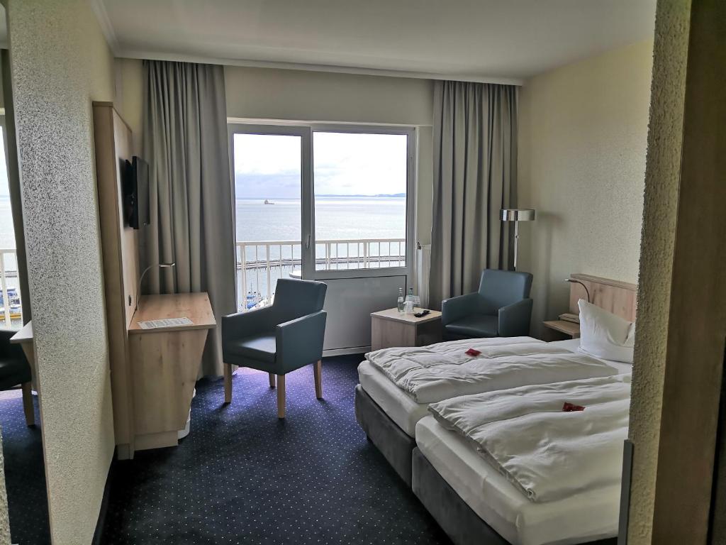 a hotel room with a bed and a view of the ocean at Rügen-Hotel in Sassnitz