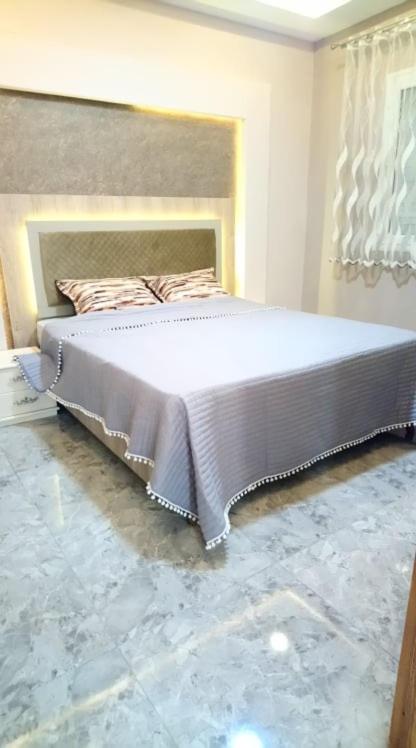 1 dormitorio con 1 cama grande en una habitación en S+2 HAUT STANDING à 200m du plage à Dar Allouche / Kélibia / Nabeul en Hanshīr Qaşr Ghallāb