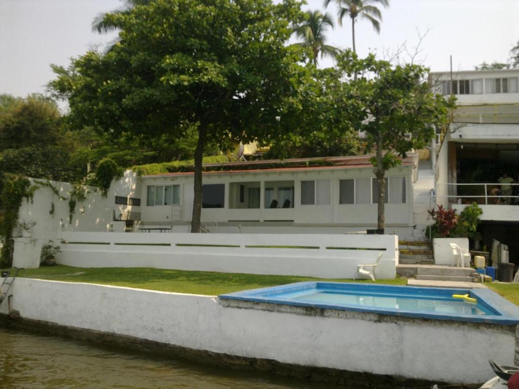 a house with a swimming pool next to a river at Hotel Los Angeles in Tequesquitengo