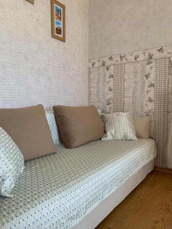 a bed with pillows on it in a room at Apartament Keti in Nesebar