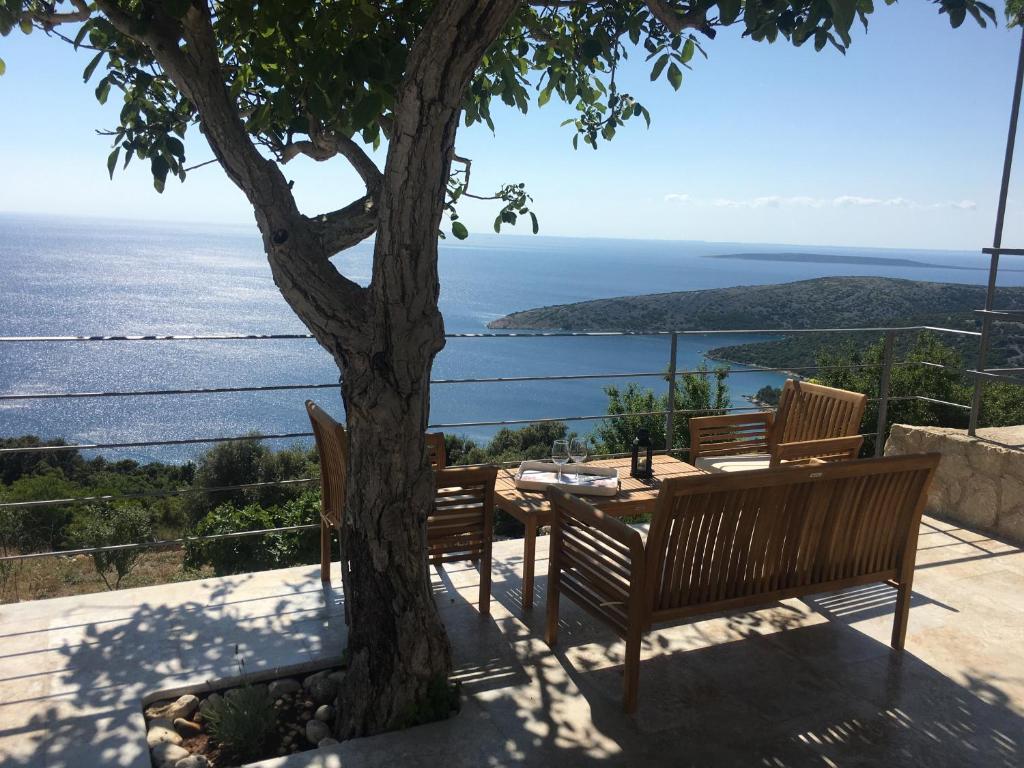 a table and chairs sitting next to a tree at House Medea in Ustrine