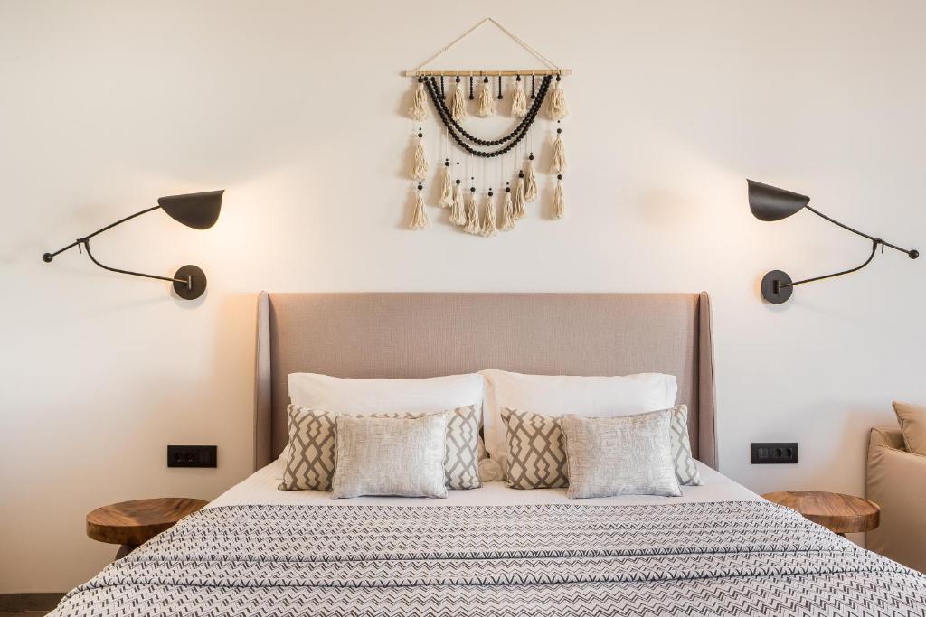 a bedroom with a bed with pillows and a chandelier at Amyth of Mykonos Super Paradise in Super Paradise Beach