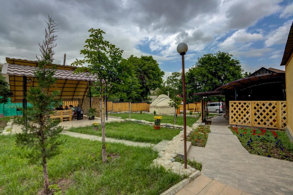 a garden with trees and a building at Guest House NAUKA#54 in Bishkek
