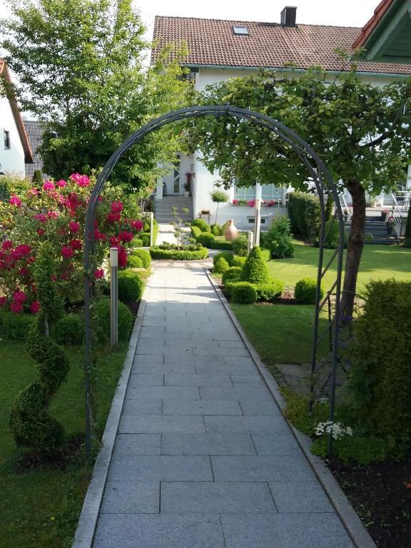 a walkway with an arch in a garden with flowers at Haus Pollak in Waldkirchen