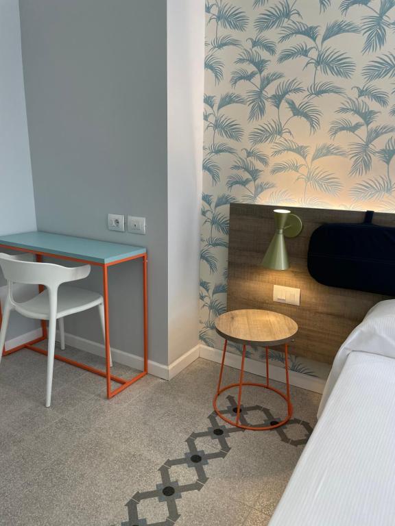 a bedroom with a desk and a table and a chair at Guerrini Hotel in Castiglioncello