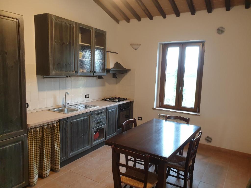 une cuisine avec une table et un évier ainsi qu'une fenêtre. dans l'établissement Podere Fogliano, à Sienne