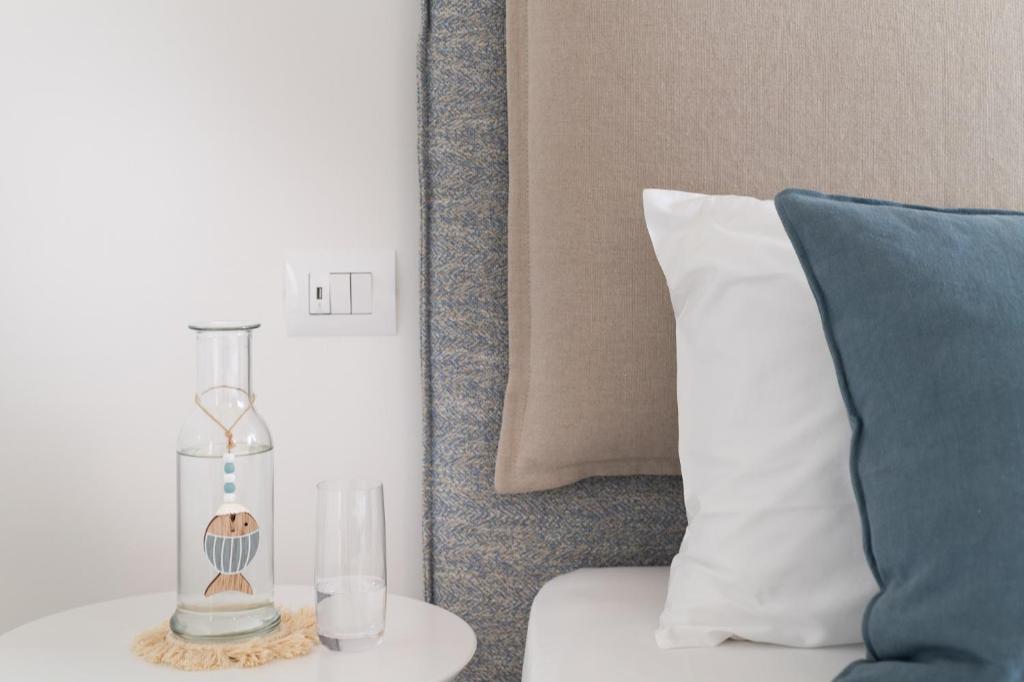 a table with a vase and a pillow next to a bed at Pareus Beach Resort in Caorle