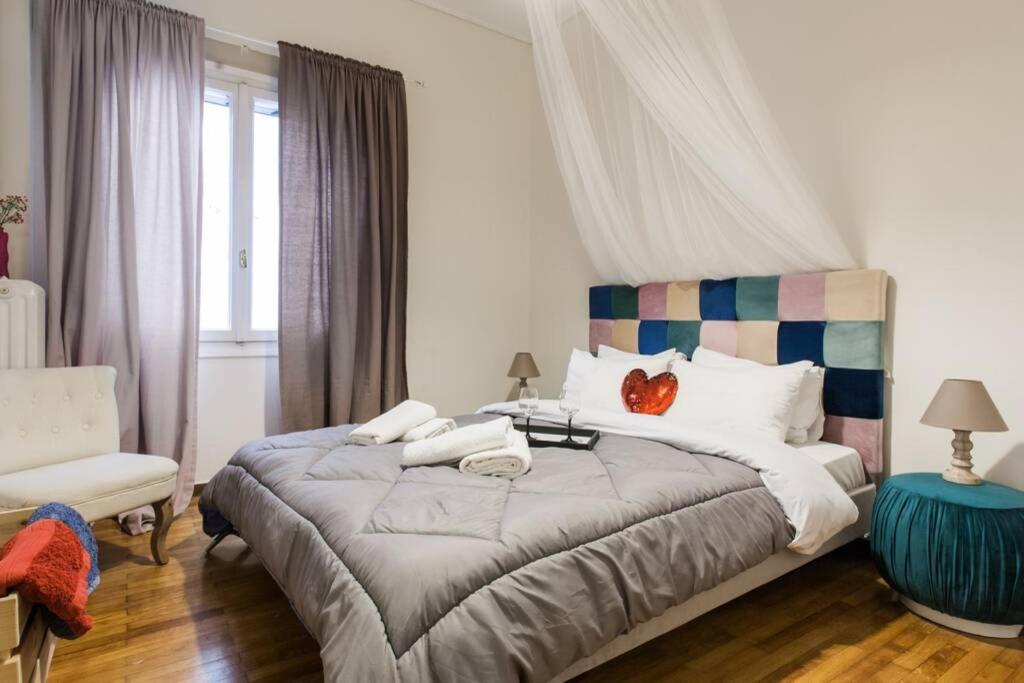 a bedroom with a large bed and a chair at Downtown Athens-Plaka Skoufou Apt/VaccinatedHost in Athens