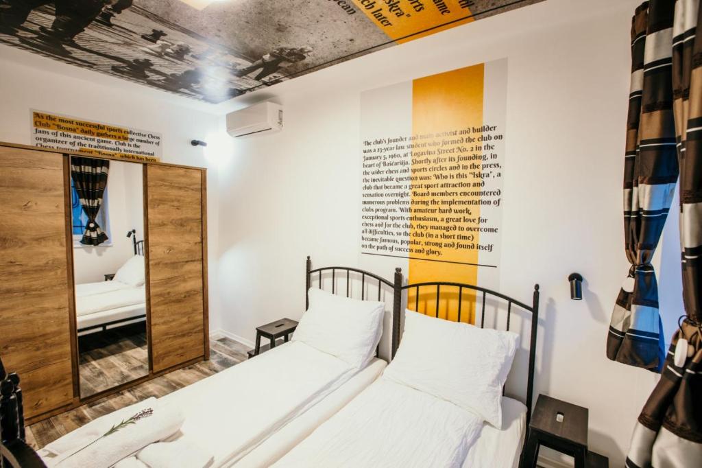 two beds in a room with a mirror at Sarajevo Stories Apartments Free Parking in Sarajevo