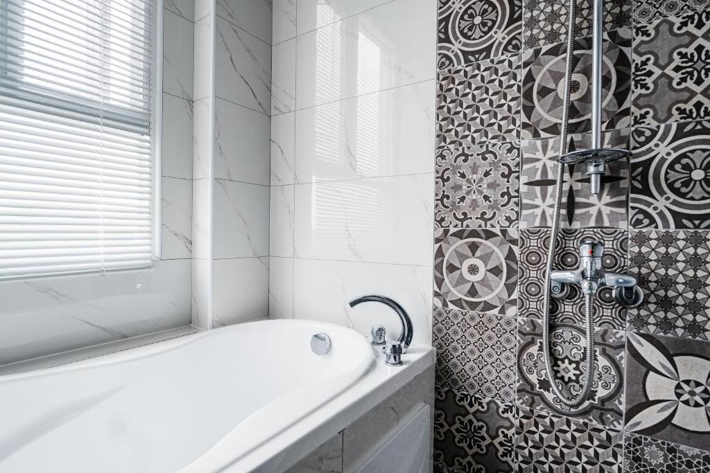 a bathroom with a bath tub and a shower at Pomelo Homestay in Houli