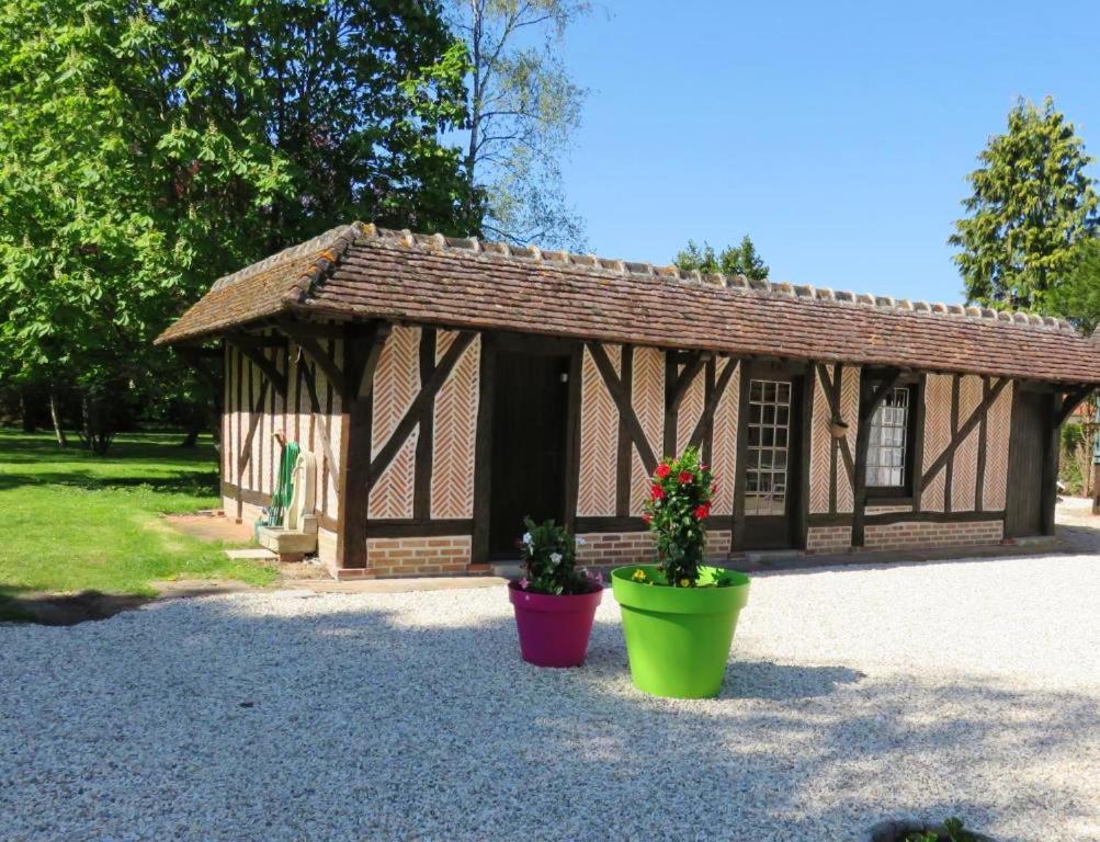 a small building with two potted plants in front of it at Maison charmante à Souvigny-en-Sologne avec jardin in Souvigny-en-Sologne