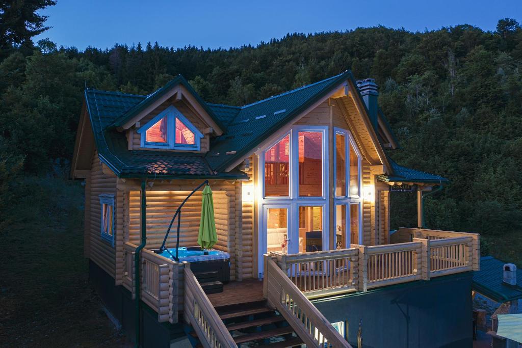 eine Blockhütte mit einer Veranda und einer Terrasse in der Unterkunft Chalet Alpin Mrkopalj in Mrkopalj