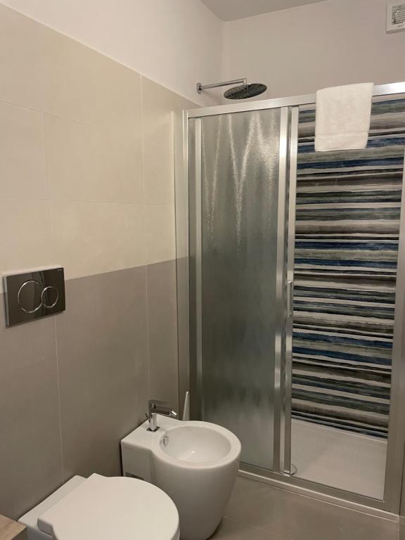 a bathroom with a shower and a toilet and a sink at Guerrini Hotel in Castiglioncello