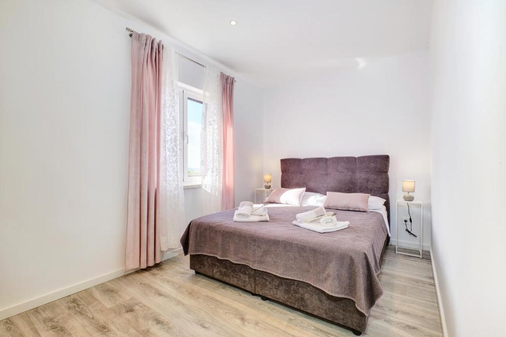 - une chambre avec un grand lit et 2 serviettes dans l'établissement Beautiful new apartment Blaz, à Mali Lošinj