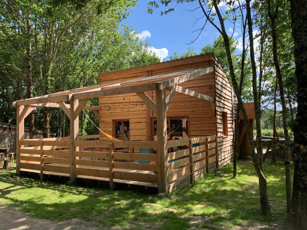 un abri en bois avec un toit dans l'herbe dans l'établissement Les Cabanes de Lou-loup écologiques et autonomes, à Anzème