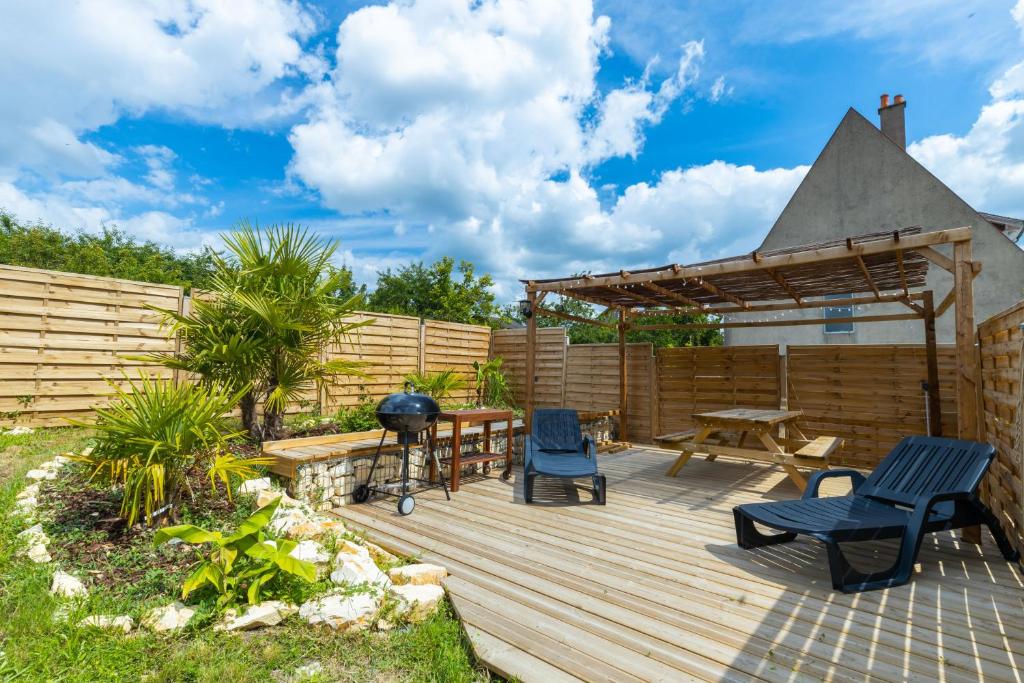 una terraza de madera con mesa de picnic y sillas en Taiiga - Domaine Tropical, en Saint-Aignan
