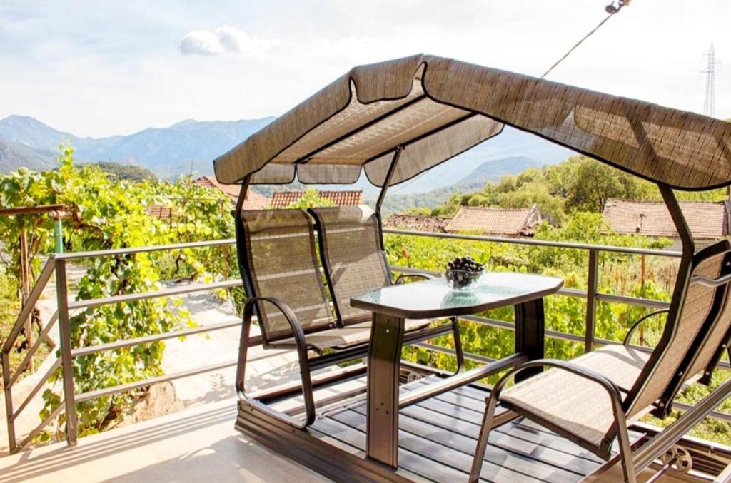 un patio con 2 sillas y una mesa en el balcón en Apartments Stella, en Virpazar