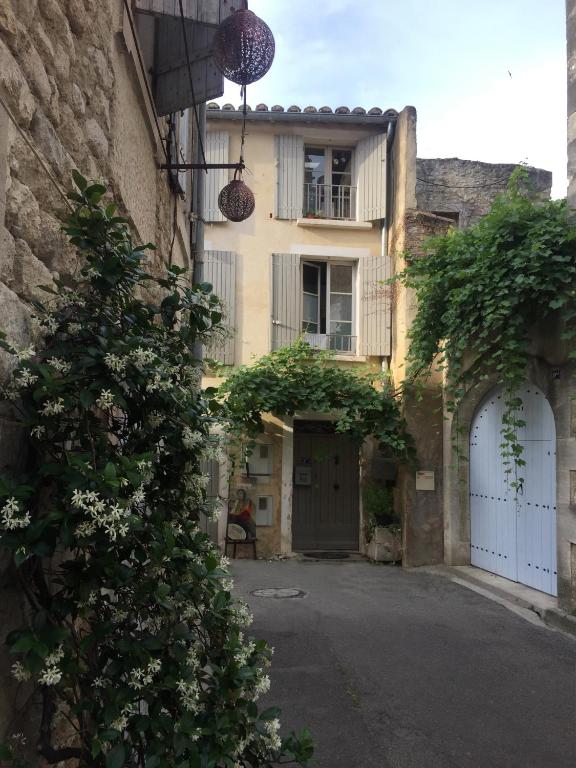 Une allée avec un bâtiment et un bâtiment avec un balcon dans l'établissement Le Lapin Blanc, à Saint-Rémy-de-Provence