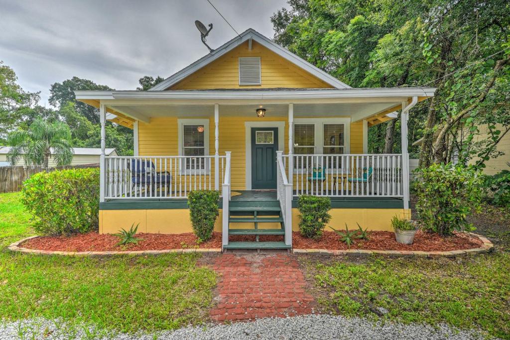 a yellow house with a front porch and stairs at Family Home Walk to Downtown and Stetson Univ! in DeLand