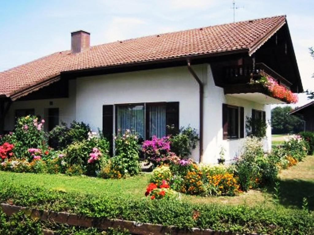 a white house with flowers in the yard at Ferienwohnung Knittler in Waging am See