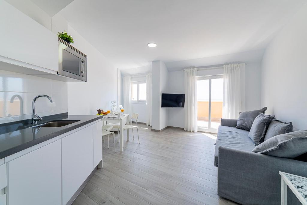 a kitchen and living room with a couch and a table at Apartamentos “Mar de Coral” Aguadulce in Aguadulce