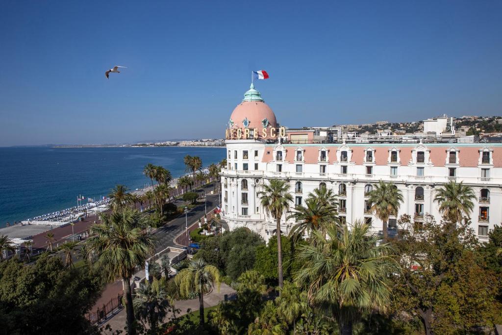 Un edificio con una cupola sopra di essa, vicino all'oceano. di Hotel Le Negresco a Nizza