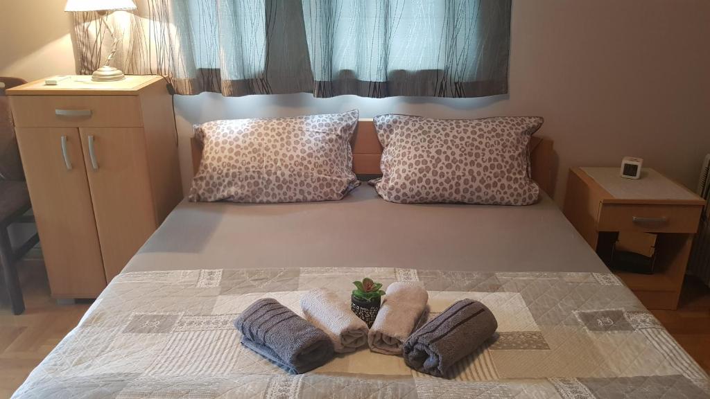 1 dormitorio con 1 cama con 2 toallas en Apartmani V&F, en Vrnjačka Banja