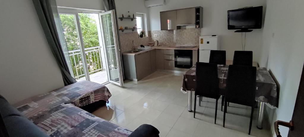 a kitchen with a table and chairs in a room at Ap Nada in Rogoznica